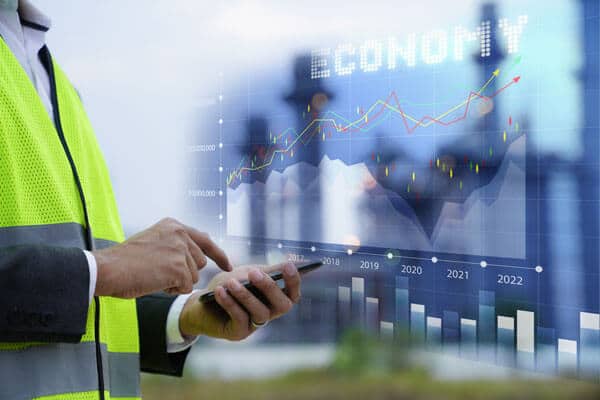 An engineer uses a phone while a graphic of feasibility charts is shown in the background
