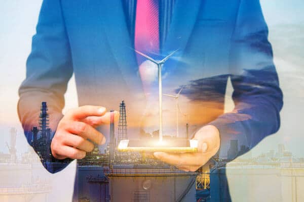 Closeup of an engineer holding a phone with a power plant overlaid on top