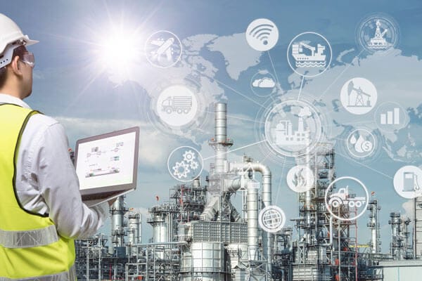 An engineer with a laptop checks the health of a power plant project